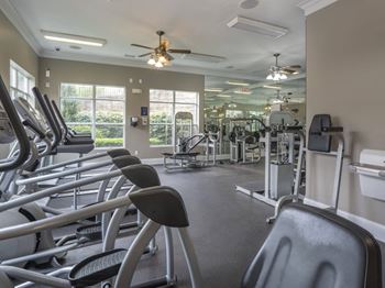 A gym with treadmills, elliptical machines, and other exercise equipment.